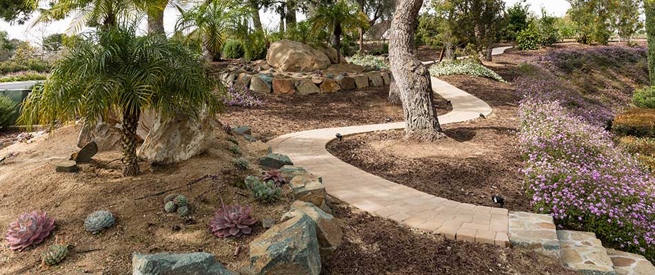 Custom stone landscaping with steps and seating in Carlsbad, CA.