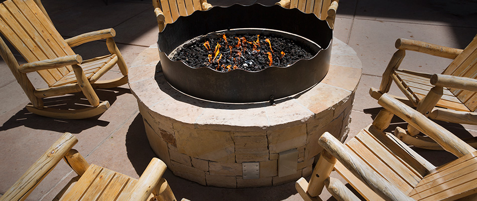 A fire pit with wooden rocking chairs surrounding the area in Encinitas, CA.
